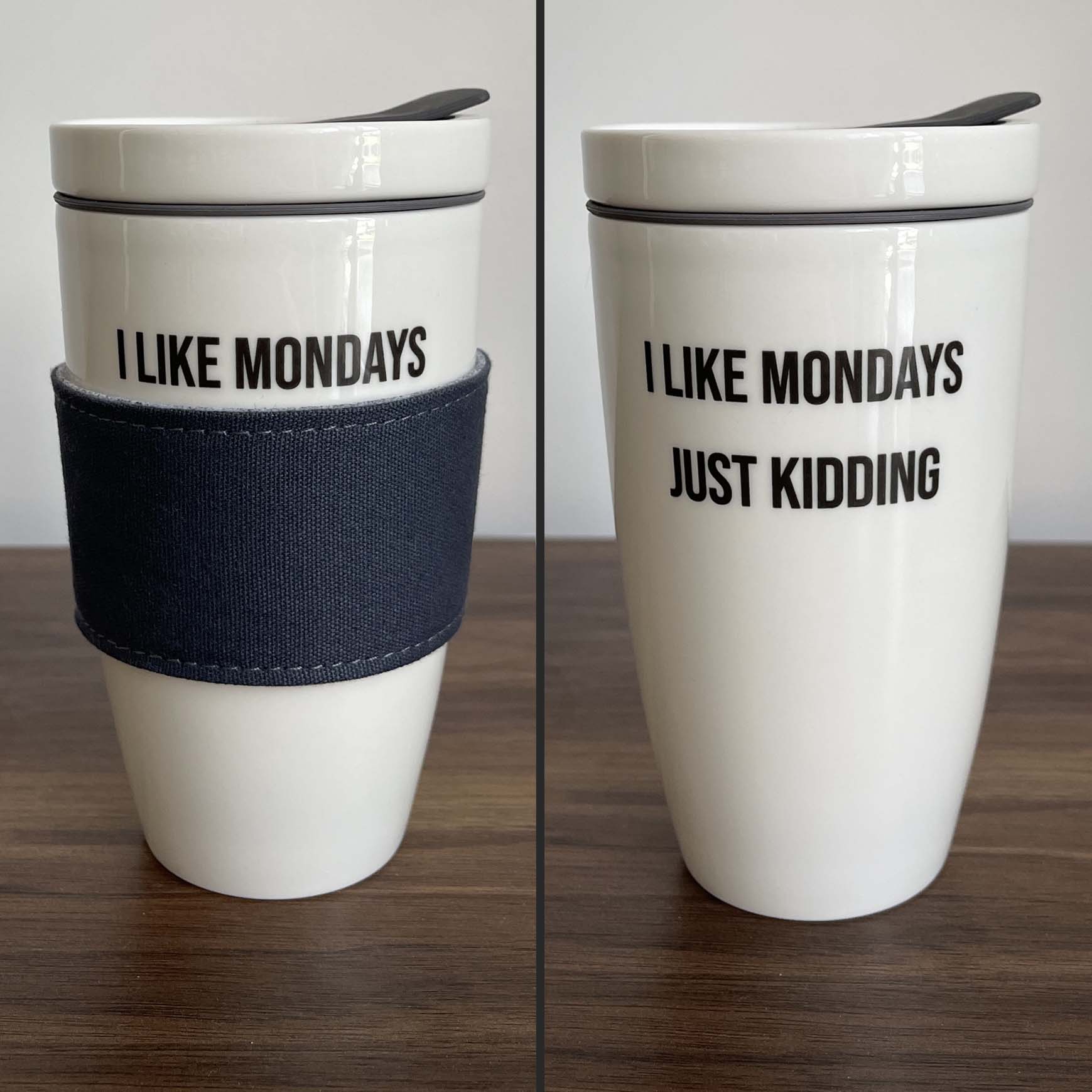 Zwei Reisebecher, auf einem steht "I LIKE MONDAYS", auf dem anderen "I LIKE MONDAYS JUST KIDDING".