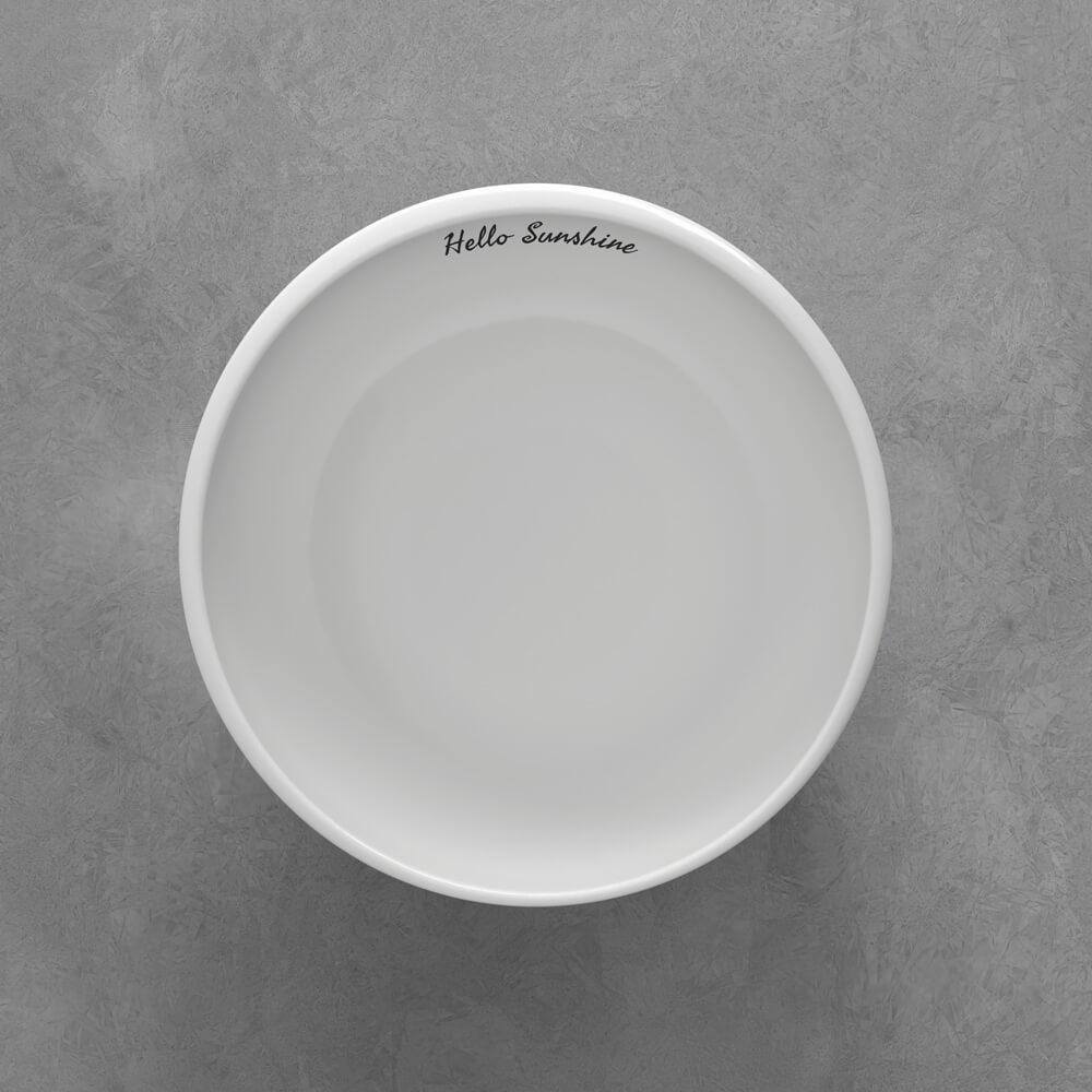 1042641900_Seaweed_schwarz Eine weiße Schale mit dem Schriftzug "Hello Sunshine" auf dem inneren Rand, platziert auf einer grauen Oberfläche.