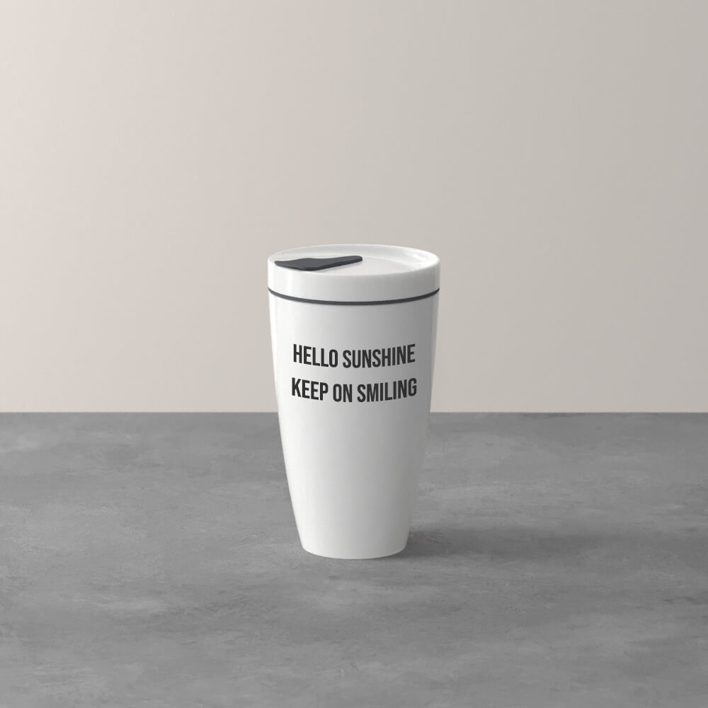 Ein weißer Reisebecher mit grauem Deckel steht auf einer grauen Fläche, in schwarzer Schrift steht "HELLO SUNSHINE KEEP ON SMILING".