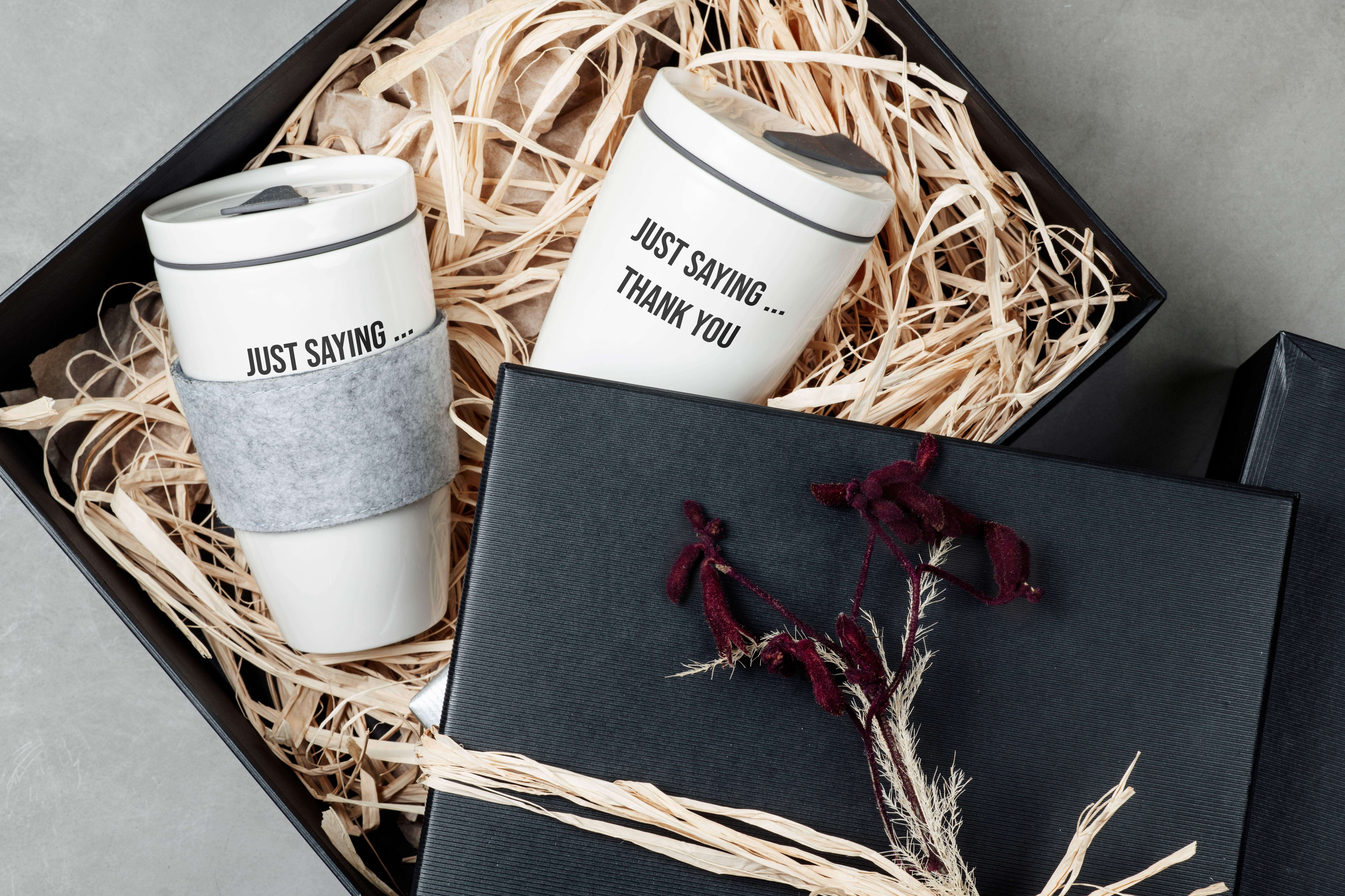 Zwei wiederverwendbare Becher mit Text